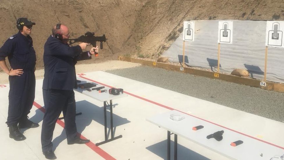 Министр полиции Нового Южного Уэльса Дэвид Эллиотт стреляет в цель из пистолета-пулемета на стрельбище в тюрьме
