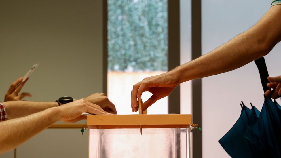 Hombre depositando el voto en la urna electoral