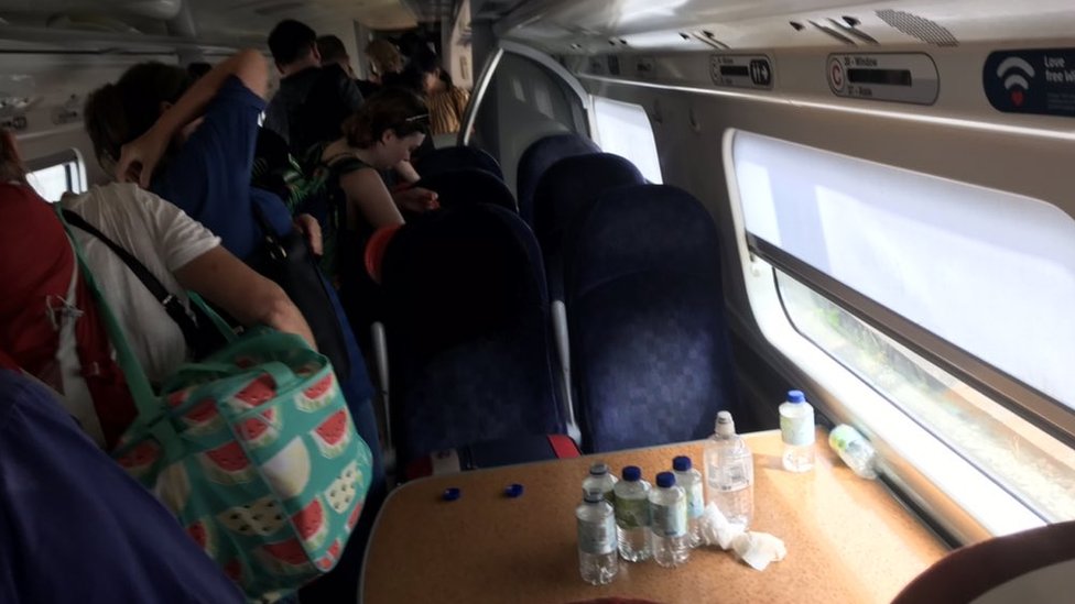 Пассажиры и бутылки с водой в переполненном поезде