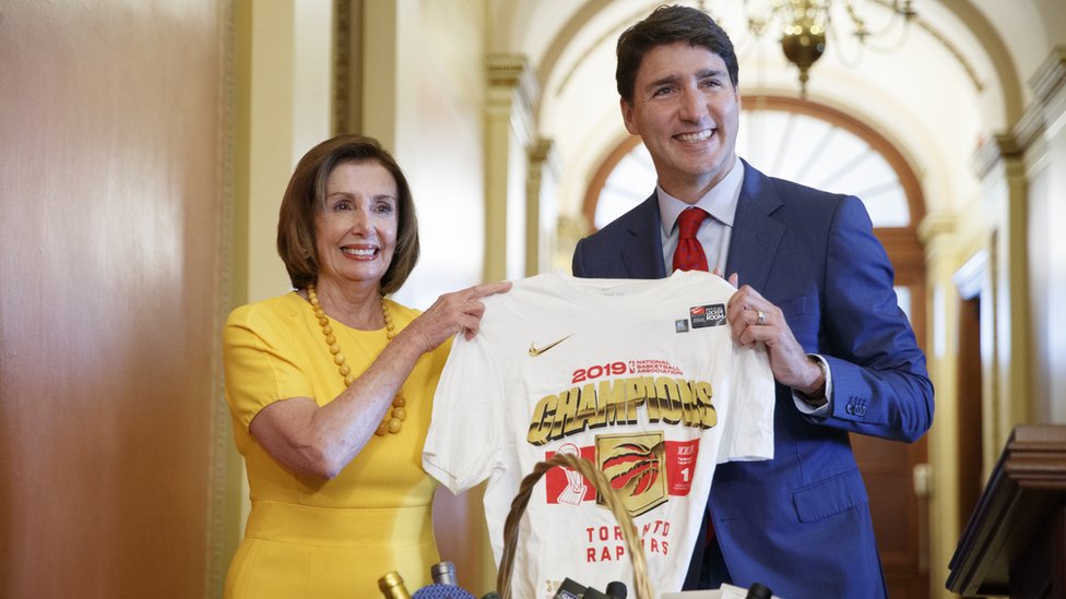 Премьер-министр Канады Джастин Трюдо держит рубашку Toronto Raptors, подаренную спикеру Палаты представителей Нэнси Пелоси