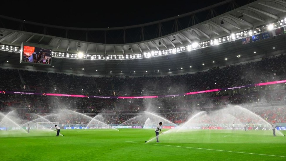 A stadium with sprinklers spraying