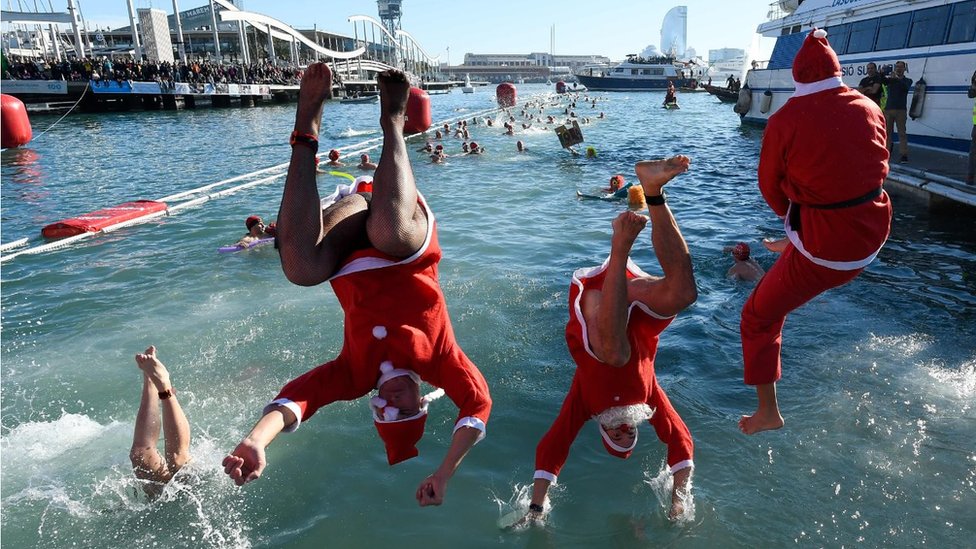 Participants in a Santa Claus costume jump into the water during the 110th edition of the "Copa Nadal" (Christmas Cup)