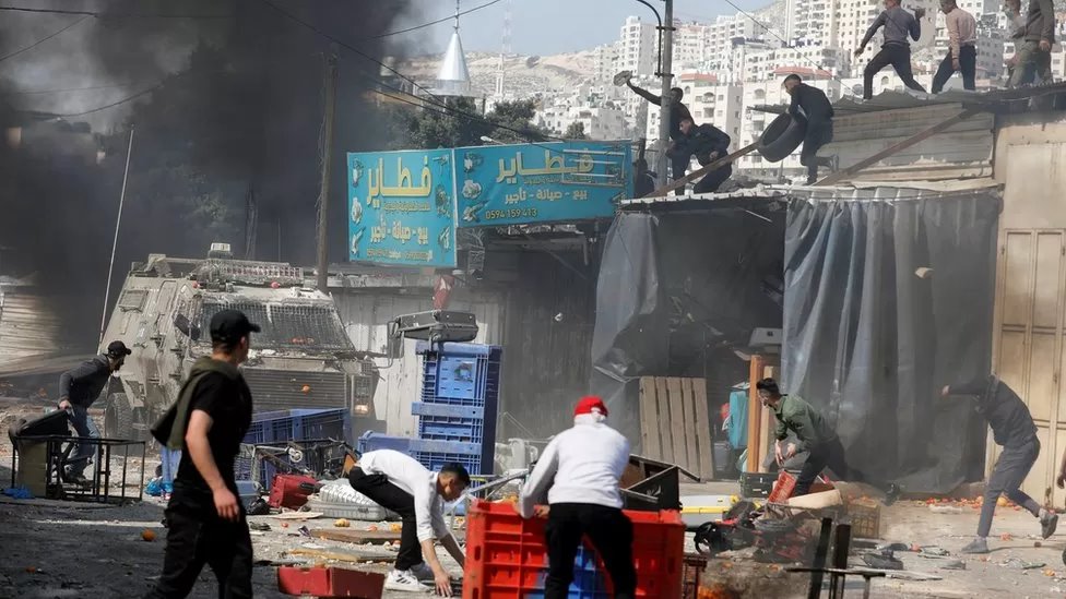 شباب فلسطينيون يلقون حجارة وأشياء أخرى على ناقلات جند مدرعة إسرائيلية