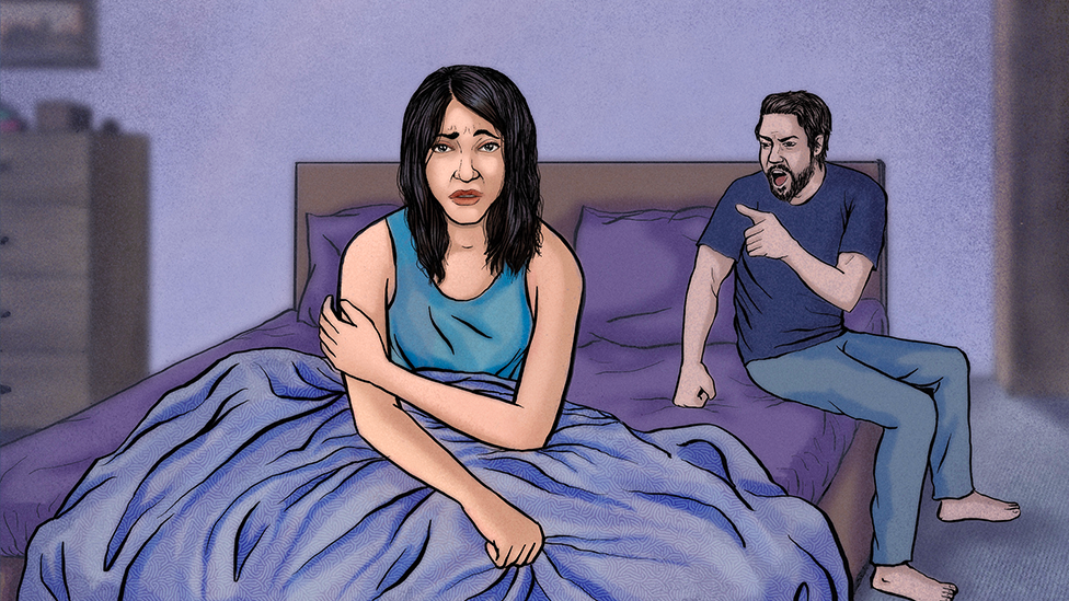 Una mujer y un hombre juntos en la cama. La mujer se ve angustiada, el hombre le grita enojado.