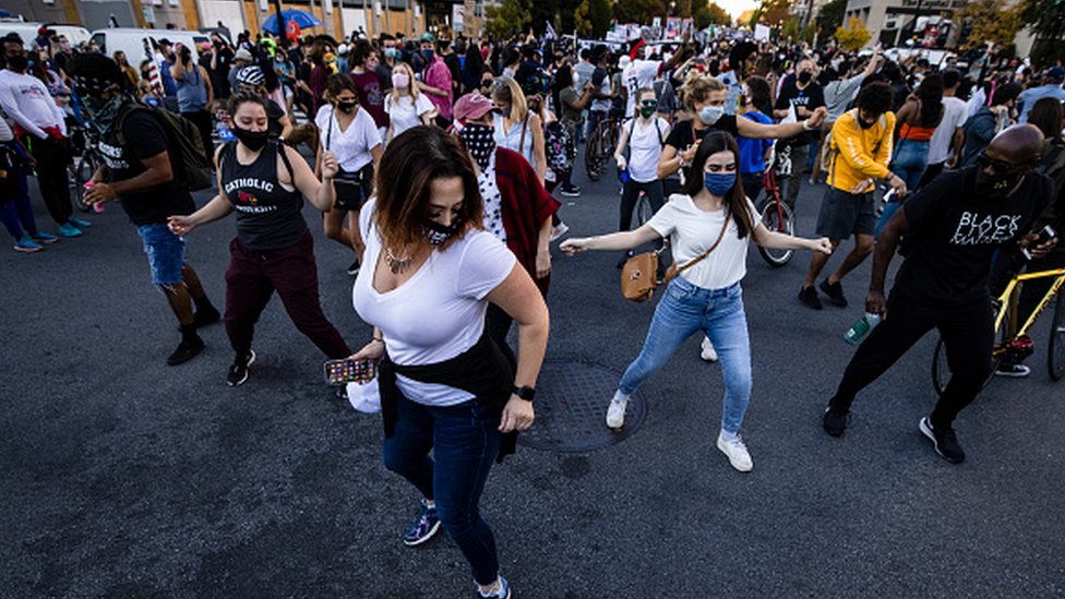 People dance in an intersection as thousands gather at Black Lives Matter Plaza near the White House