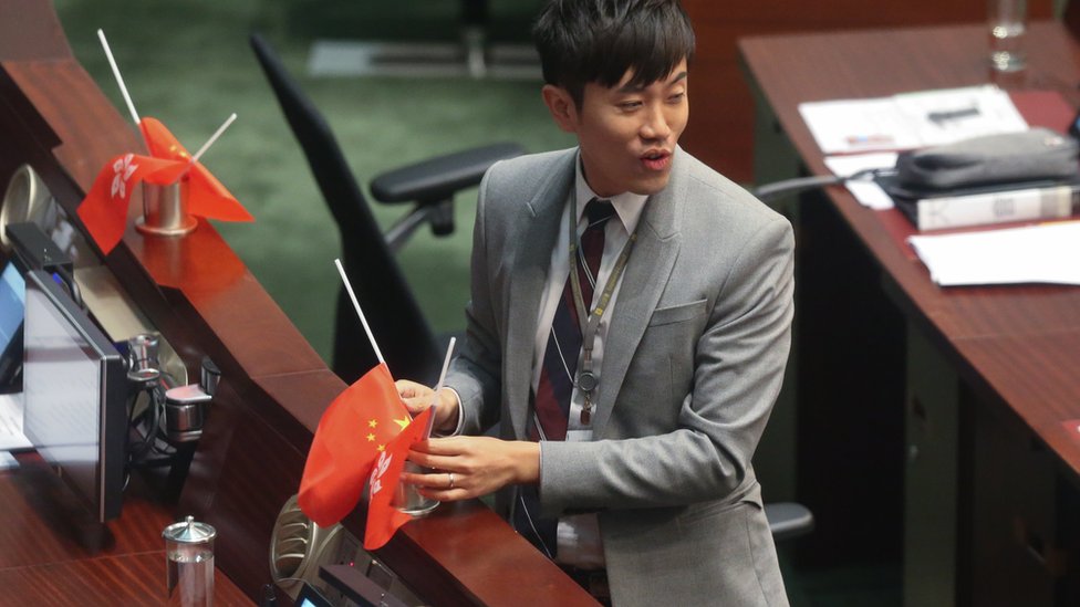鄭松泰2016年把建制派議員桌上的中國國旗和香港區旗倒插，被法庭罰款，他去年就事件致歉，指自己的"表達方式確實不對"。
