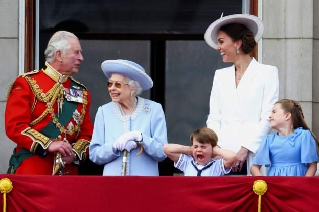 女王、查爾斯王儲和其他擔任皇室職務的王室成員在白金漢宮陽台上閲兵，觀看飛行表演