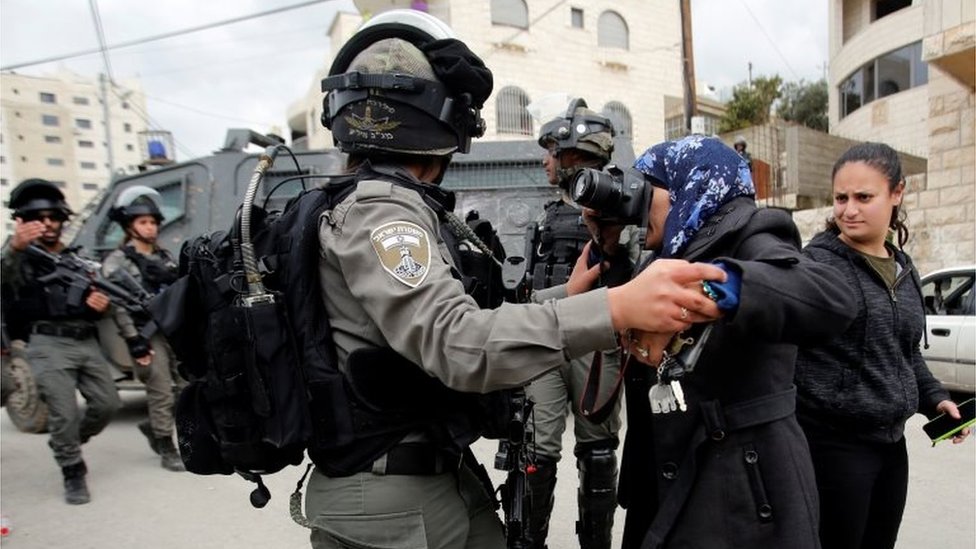 A local photographer takes pictures as an Israeli border police member holds her back during the demolition of a Palestinian house whose owners said they were informed by the Israeli forces that they didn't obtain a construction license, in Beit Jala in the Israeli-occupied West Bank on 2 April 2019.