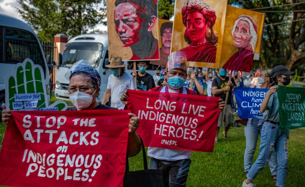 Climate activists hold up signs next to portraits of slain Philippine environmental defenders as they take part in a Global Day of Action for Climate Justice protest on November 06, 2021 in Quezon city, Metro Manila, Philippines.