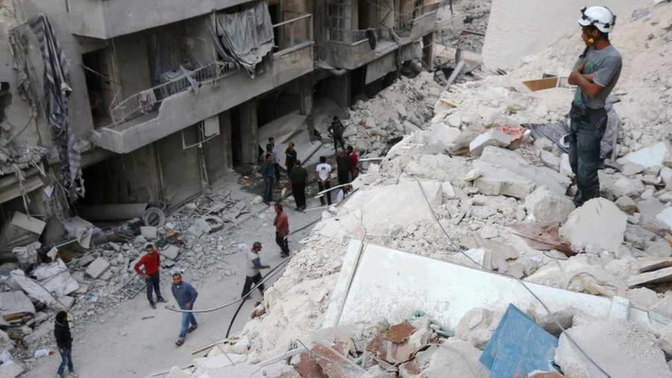 Сирийцы среди разрушенных зданий в Алеппо, октябрь 2016 г.