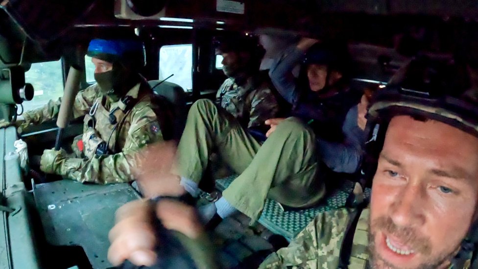 The sniping team, alongside the BBC's Jonathan Beale and cameraman Moose Campbell, inside a vehicle near Bakhmut