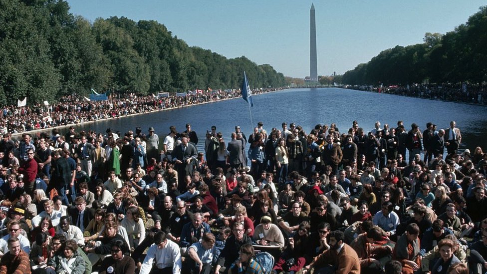 Para pengunjuk rasa di kerumunan anti-Perang Vietnam berkumpul di sekitar kolam refleksi di Monumen Washington di Washington, DC, 21 Oktober 1967