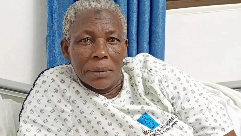 Safina Namukwaya na maca de hospital olhando para foto