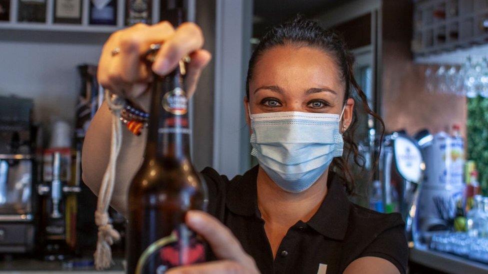 Una camarera sirve una cerveza