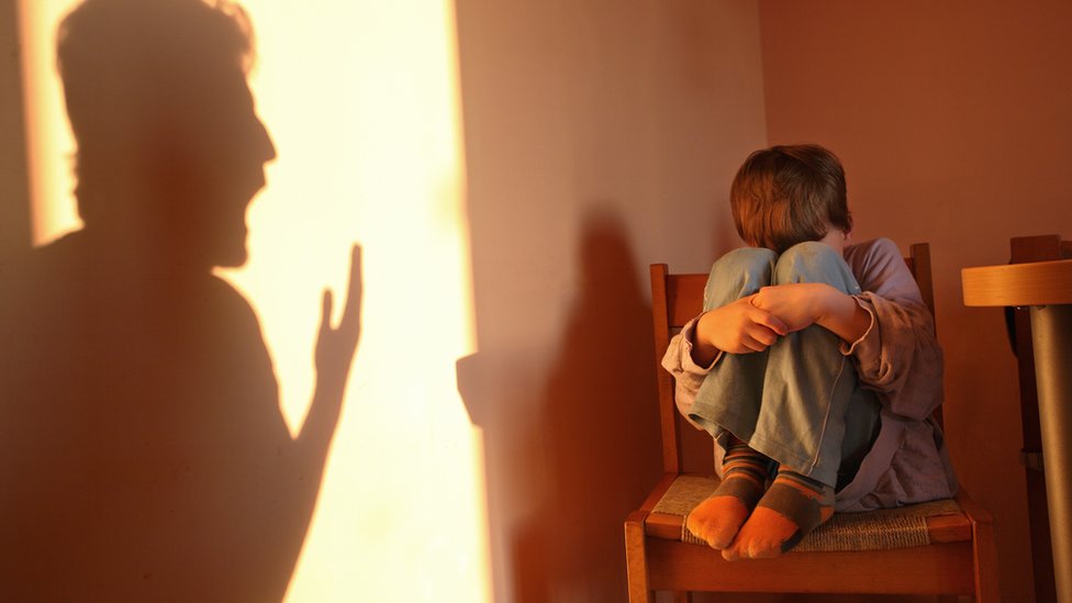 La agresión de su padre le aterraba, y sin poder ver, los ruidos que escuchaba lo asustaban. niño asustado con sombra de padre gritando
