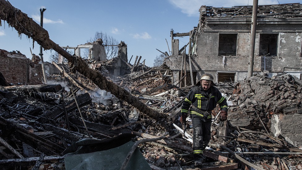 Un bombero camina entre ruinas de edificios bombardeados en Járkiv