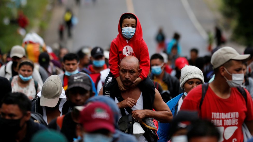 Un hombre lleva a un niño en sus hombros. Ambos integran la caravana de migrantes que partió de Honduras y pretende llegar a Estados Unidos.