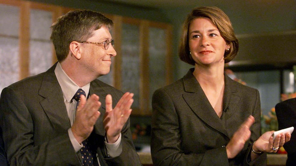 Билл Гейтс смотрит на свою жену Мелинду во время пресс-конференции в Сиэтле в 1999 году