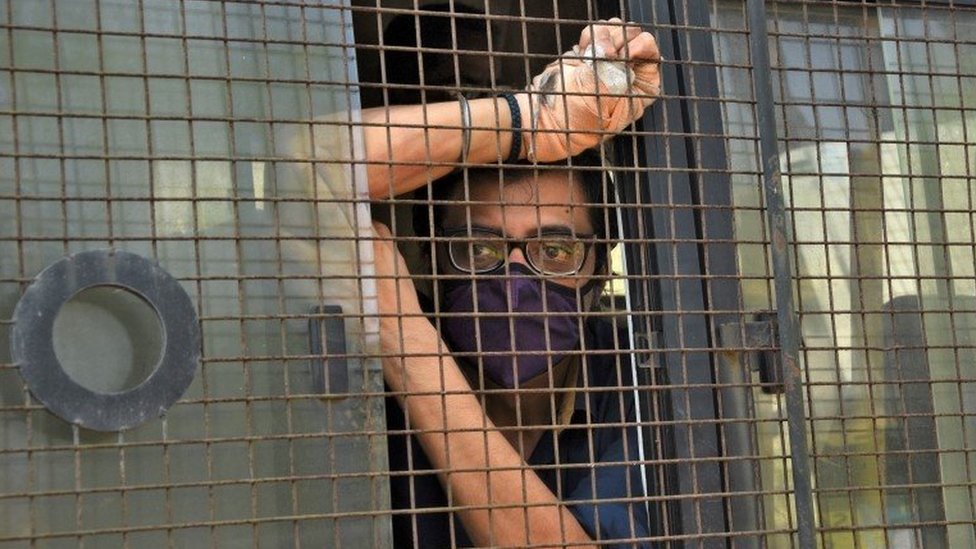 Arnab Goswami, one of India"s top TV news anchors, sits inside a police van outside a court after he was arrested, at Alibaug town in the western state of Maharashtra, India, November 4, 2020.