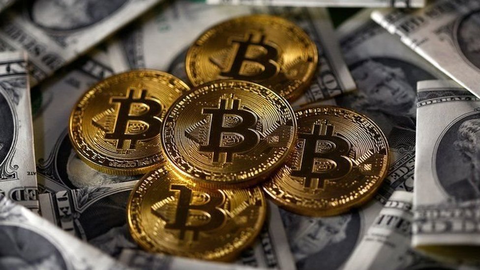 Billetes de dólares y monedas que representan bitcoins