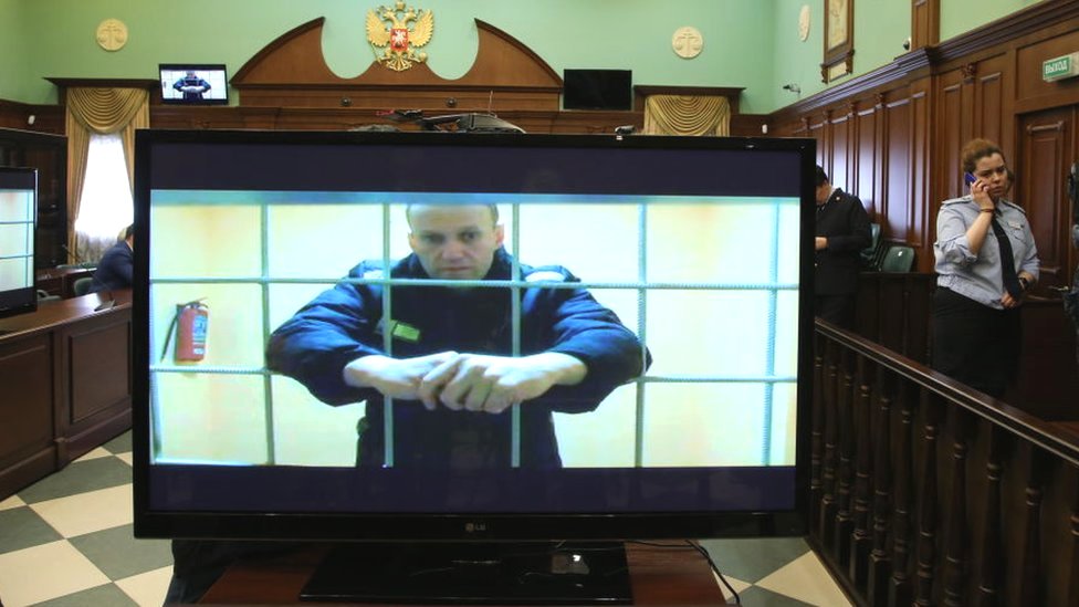 روسيا وأوكرانيا: ما ثمن معارضة فلاديمير بوتين؟ 2 Russian opposition politician Alexei Navalny is seen on screen during his legal appeal against his nine-year prison sentence, in Moscow, 24 May 2022