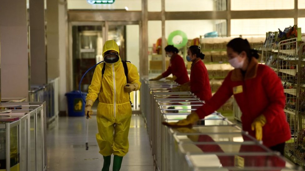Empregado desinfeta loja em Pyongyang em 18 de marco de 2022