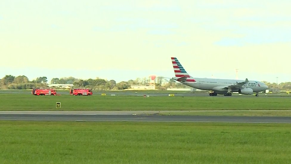 Пожарные сопровождают самолет American Airlines, пока он курсирует по взлетно-посадочной полосе в аэропорту Дублина