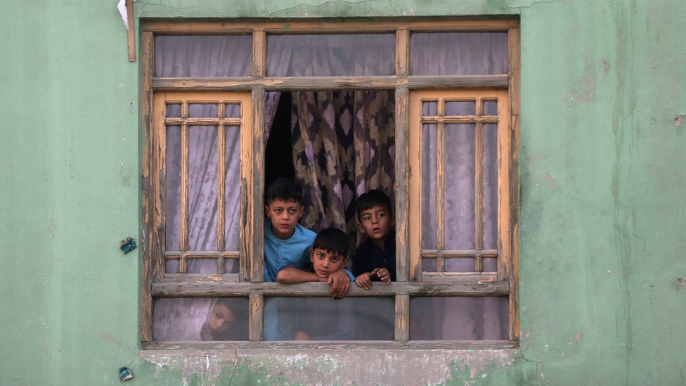 Афганские дети смотрят из окна
