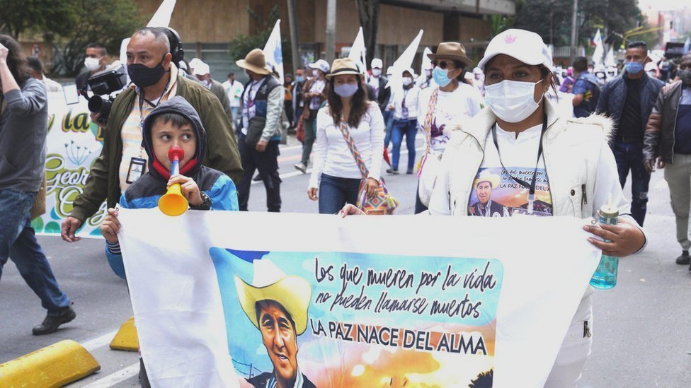 Бывший боец ??Farc Луз Марина Хиральдо идет к центру столицы Колумбии, неся знамя с изображением своего партнера.