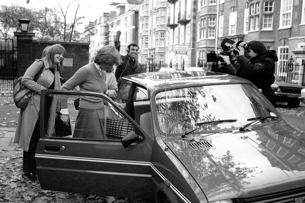 La princesa Diana se sube a un auto rodeada de periodistas