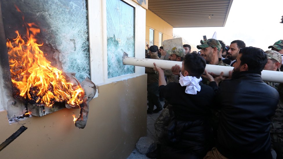 Члены иракской шиитской вооруженной группировки «Силы народной мобилизации» и их сторонники атакуют вход в посольство США в Багдаде, 31 декабря 2019 г.