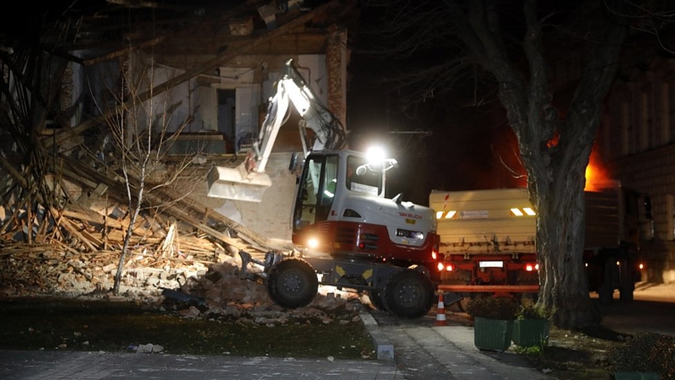 Workers clear a building damaged in an earthquake in Petrinja, Croatia, 29 December 2020