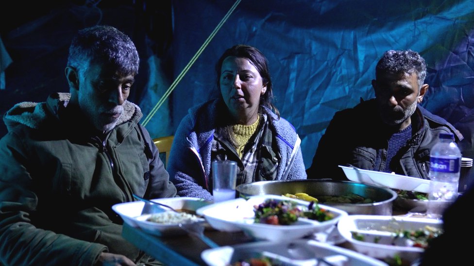 أصبحت سونغول يوسيسوي (في الوسط) الآن بلا مأوى، تبدو هنا وهي تتناول الطعام بجانب خيمة