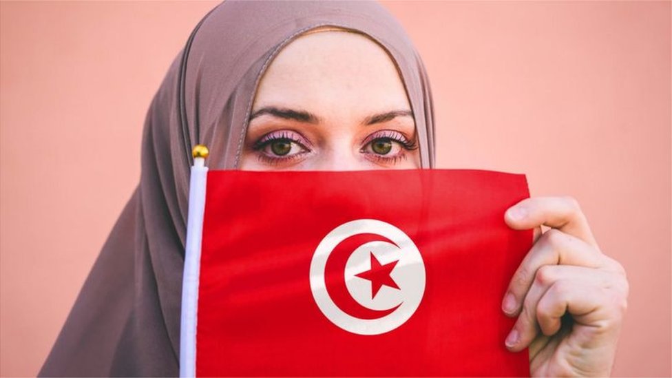 امرأة تمسك العلم التونسي