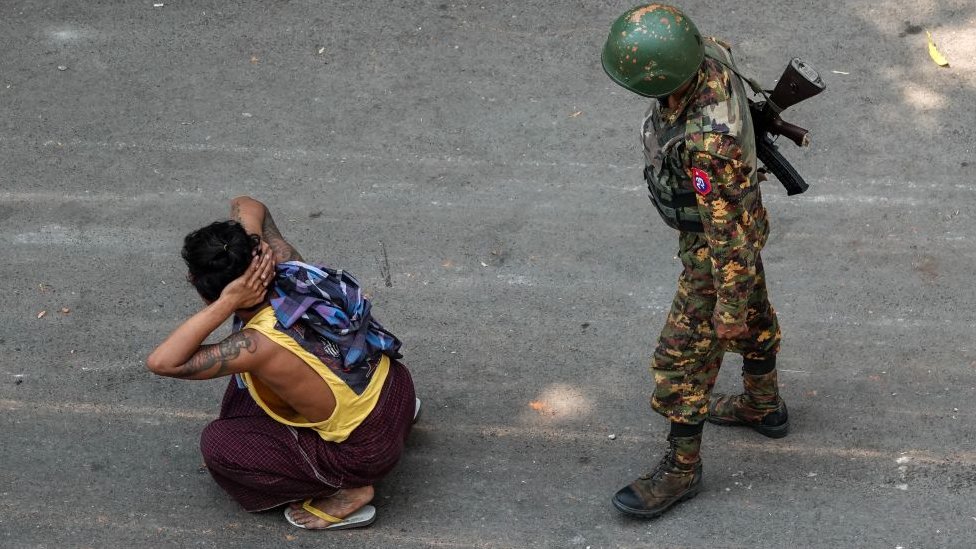 Um soldado ao lado de um homem detido durante uma manifestação contra o golpe militar em Mandalay em 3 de março de 2021