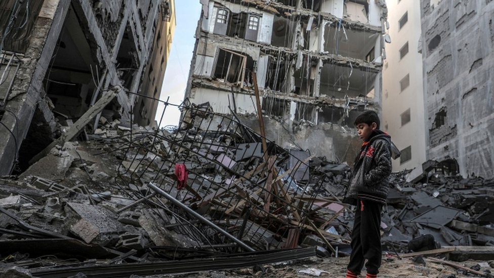 طفل فلسطيني يقف على أنقاض مبنى دمره القصف الإسرائيلي لغزة