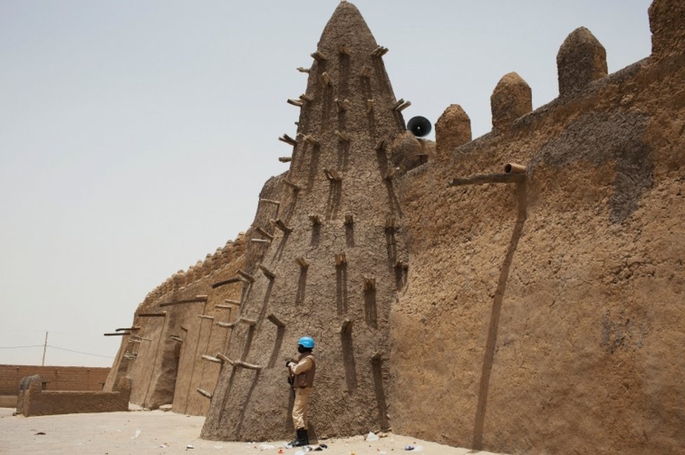 Миротворец ООН из Буркина-Фасо стоит на страже у мечети Джингеребер 14 века в Тимбукту, Мали