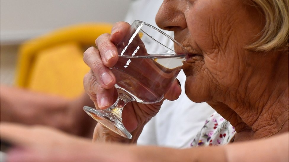 Mujer mayor bebiendo agua