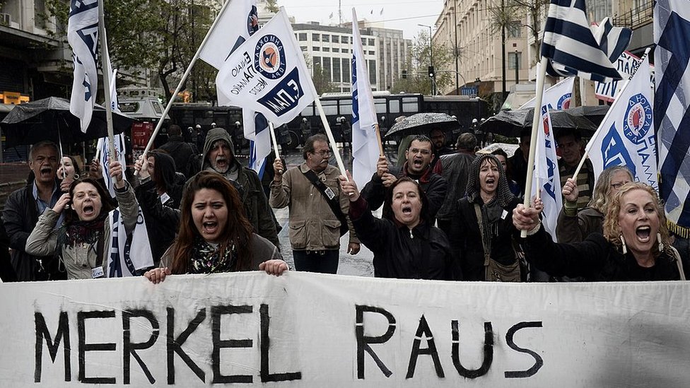 People demonstrate by a police blockade during a demonstration against the visit of the German Chancellor Angela Merkel in Athens on April 11, 2014