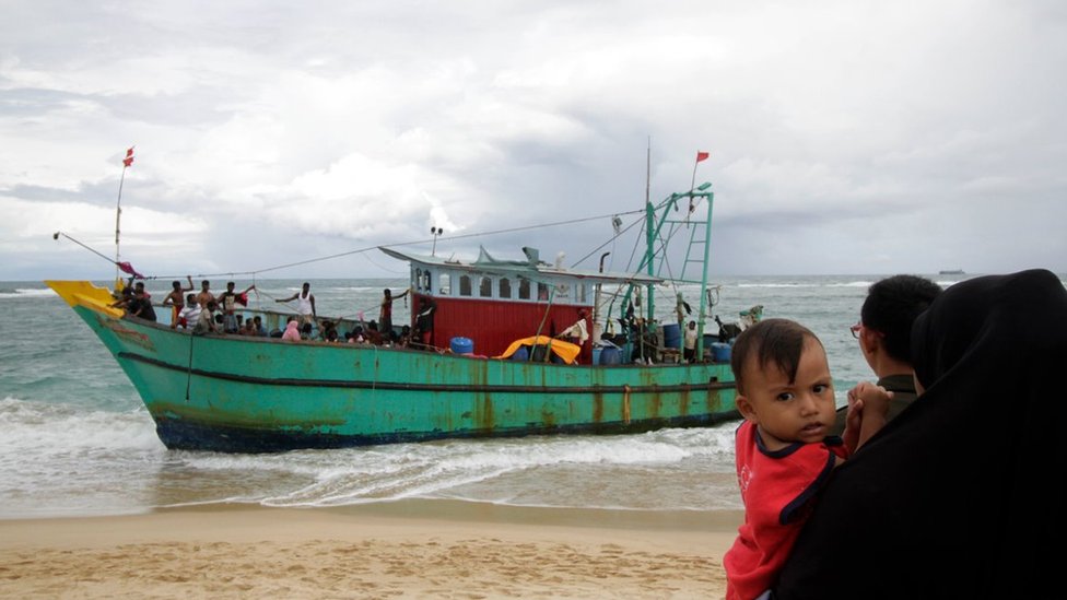 Migrants from Sri Lanka remain on their boat despite their vessel being washed ashore on the west coast of Lhoknga on June 14, 2016 in Aceh Besar, Indonesia. Dozens of Sri Lankan immigrants bound for Australia were stranded off Aceh in northwest Indonesia after their boat broke down, local officials said on June 12.