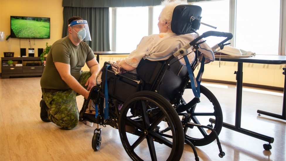 Канадский солдат помогает пожилому гражданину в центре долгосрочного ухода в Монреале, Квебек, 10 мая