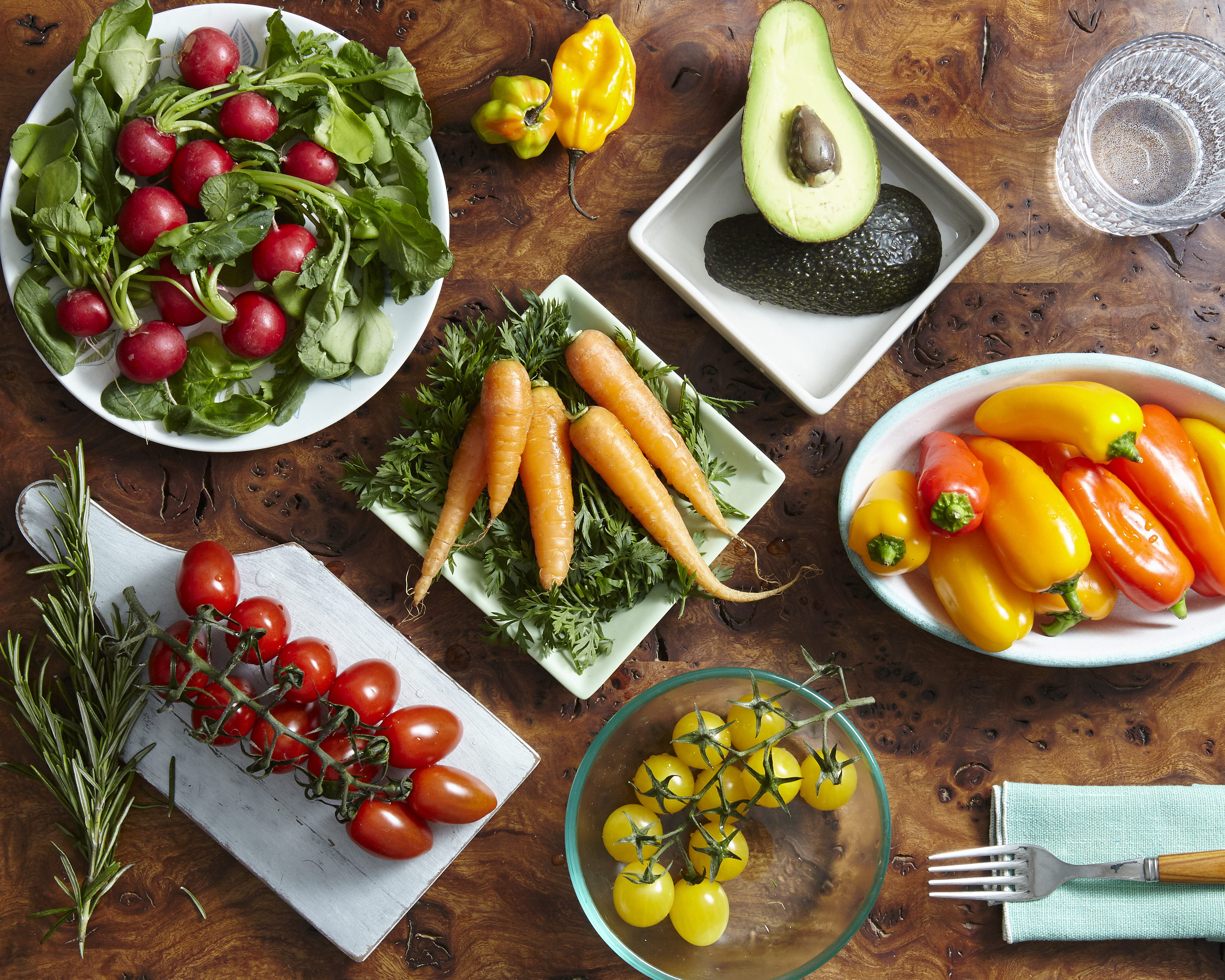 Varios platos con vegetales como tomate y pimientos