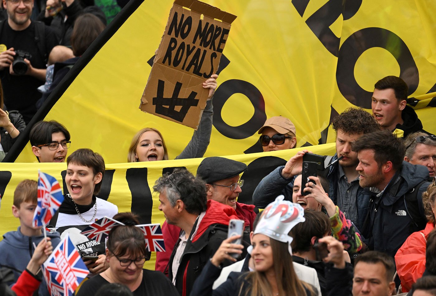 Anti-royal protestors hold up placards saying 'Not My King' as they demonstrate behind well-wishers in Trafalgar Square