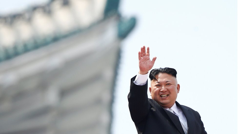 Лидер Северной Кореи Ким Чен Ын машет рукой людям, присутствующим на военном параде по случаю 105-й годовщины со дня рождения отца-основателя страны Ким Ир Сена в Пхеньяне, 15 апреля