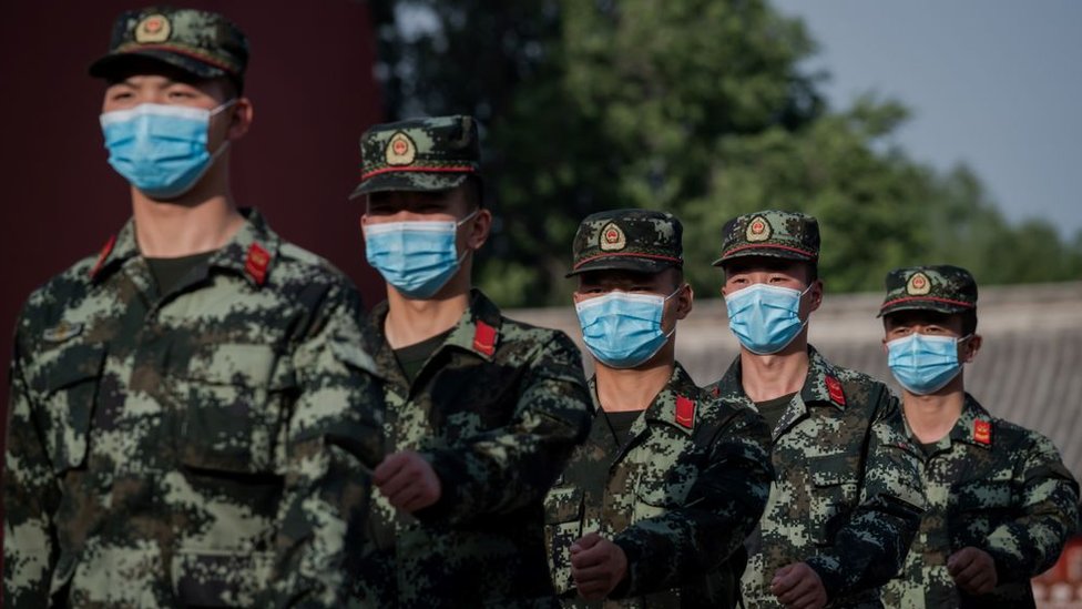 PLA troops march with face masks on in Beijing