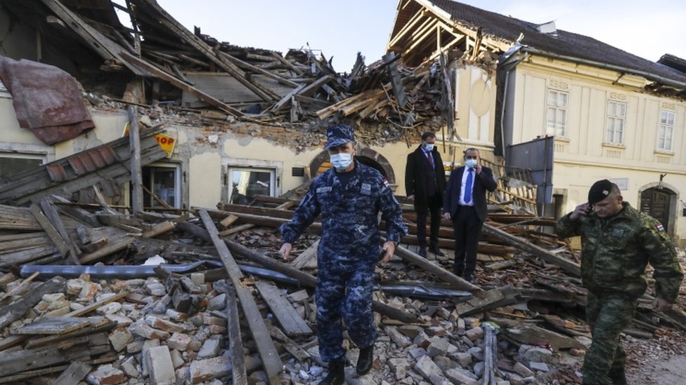 Croatian soldiers and officials walk through the rubble from buildings damaged in an earthquake in Petrinja, Croatia, 29 December 2020