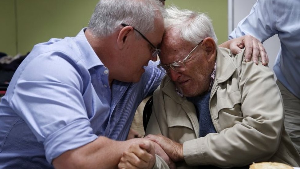 Премьер-министр Австралии Скотт Моррисон утешает Оуэна Уолана, жителя Нового Южного Уэльса, который был эвакуирован