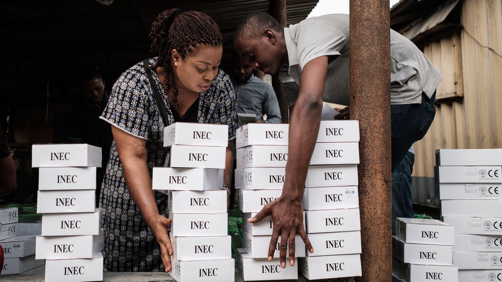 Сотрудники избирательных комиссий Нигерии с машинами для чтения карт