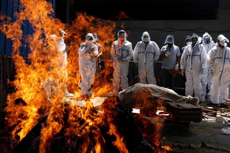 Relatives attend the cremation of a Covid victim in New Delhi, India