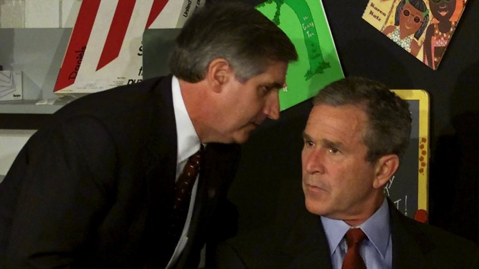 U.S. President George W. Bush listens as White House Chief of Staff Andrew Card informs him of a second plane hitting the World Trade Center while Bush was conducting a reading seminar at the Emma E. Booker Elementary School, in Sarasota, Florida, September 11, 2001.